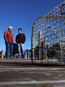 VIMS graduate student Jim DelBene (R) and professional mentor J.C. Hudgins discuss derelict crab pots along a dock on Gwynn's Island. © Aileen Devlin | Virginia Sea Grant.