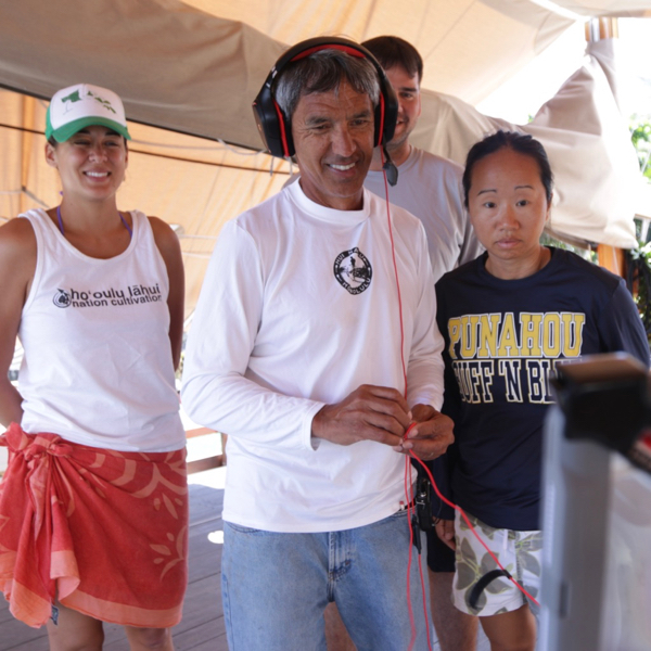 Nainoa Thompson (C) engages in an online discussion with students in Hawaii as crewmembers Maya Saffrey, Maui Tauotaha and Linda Furuto look on. © Polynesian Voyaging Society.