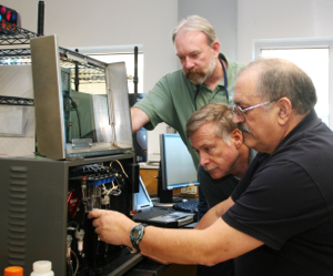 VIMS researchers Mike Unger, Wolfgang Vogelbein, and Steve Kaattari with the biosensor in the lab at VIMS. Photo by Rosemary Hicks.